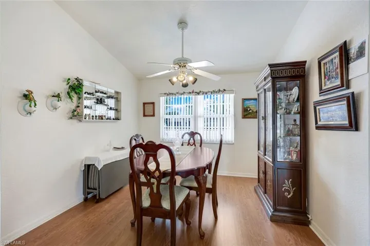 Dining space with ceiling fan, baseboards, vaulted ceiling, and wood finished floors