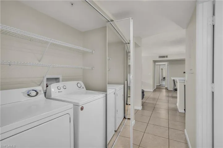 Laundry area featuring separate washer and dryer and light tile patterned flooring