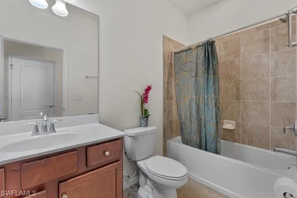 Bathroom with shower / bathtub combination with curtain and vanity