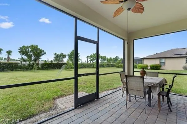 Sunroom / solarium with a ceiling fan and outdoor dining space