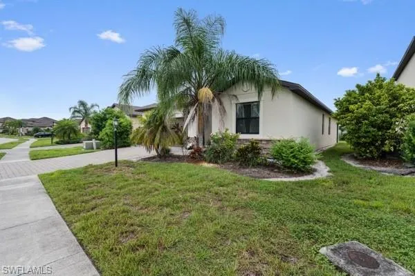 View of front of property featuring a front yard, stucco siding, and driveway