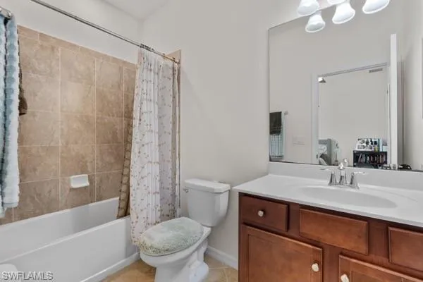Bathroom with shower / bath combo, vanity, and light tile patterned floors