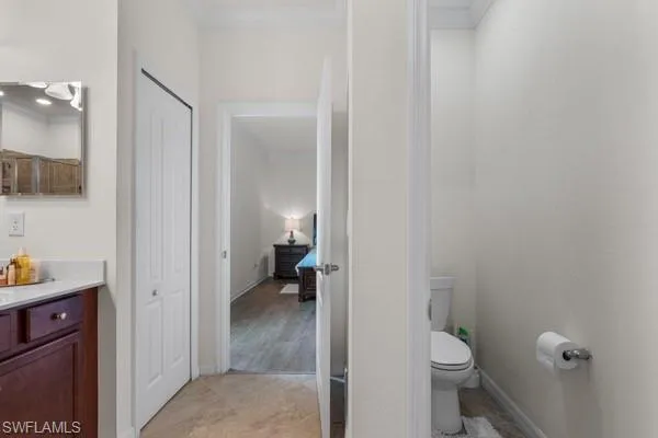 Bathroom with vanity, crown molding, and light tile patterned floors