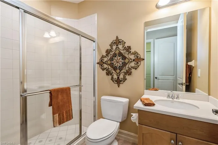 Bathroom with vanity, toilet, and an enclosed shower