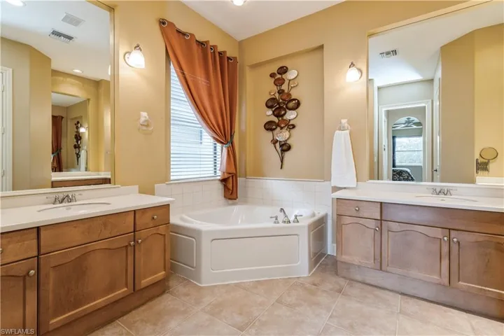 Bathroom featuring tile patterned flooring, vanity, and a tub
