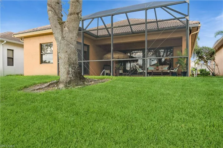 Rear view of property with a lawn and glass enclosure