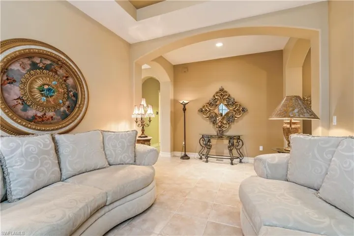 Living room with light tile patterned flooring and a chandelier