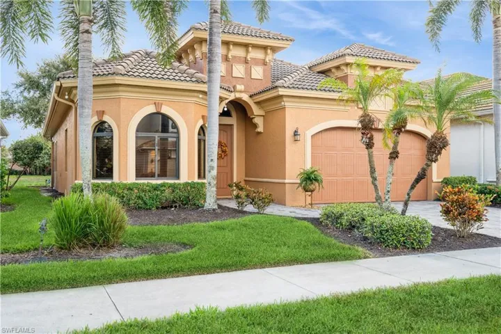 Mediterranean / spanish home featuring a front yard and a garage
