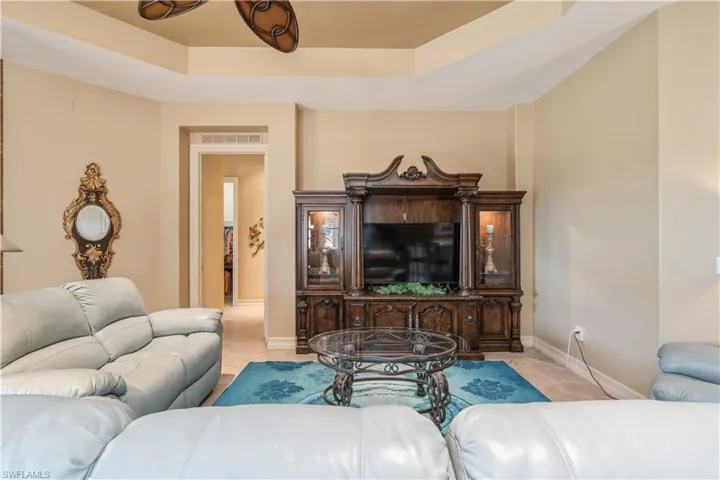 Living room with light tile patterned flooring and a raised ceiling