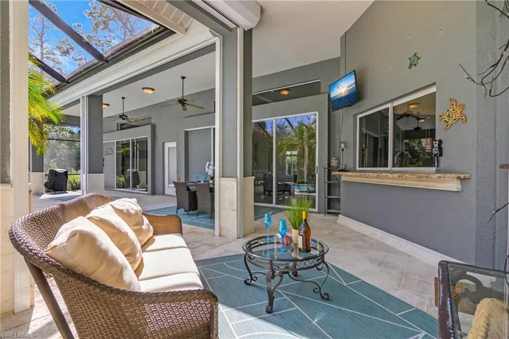 View of Lanai featuring a ceiling fan and outdoor dining area and electric storm shutters