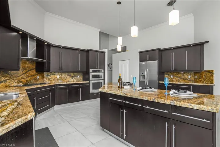Kitchen with backsplash, a center island, stainless steel appliances, ornamental molding