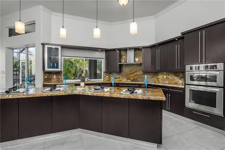 Kitchen with wood finish cabinetry, tasteful backsplash, double oven, crown molding, and a kitchen island