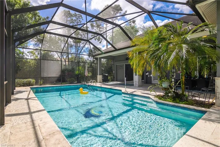 Outdoor pool with a patio, a sunroom, and a lanai