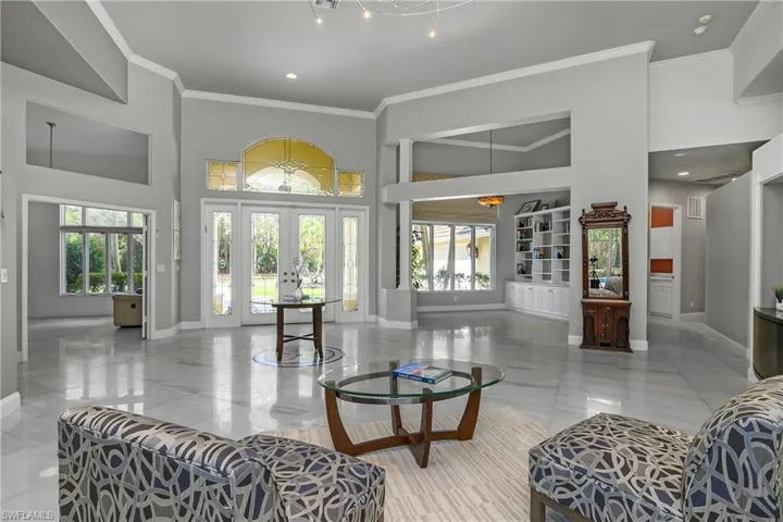 Formal Living room with a high ceiling, crown molding, french doors, and recessed lighting