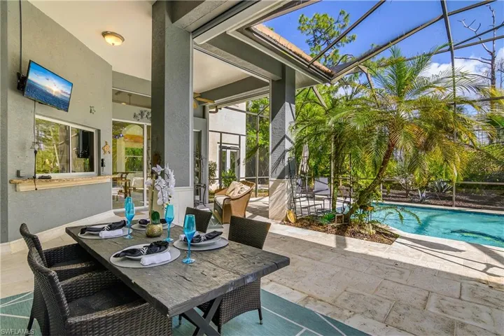 View of patio / terrace featuring outdoor dining area, a sunroom, an outdoor pool, and a lanai
