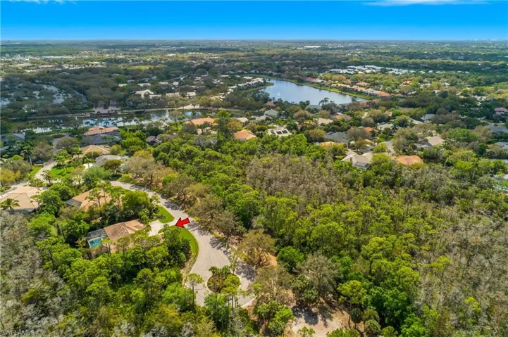 Red arrow points to the home with only one neighbor and an Aerial view of residential area with a large body of water