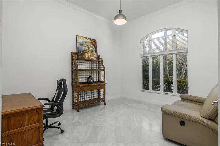 Home office with crown molding and baseboards