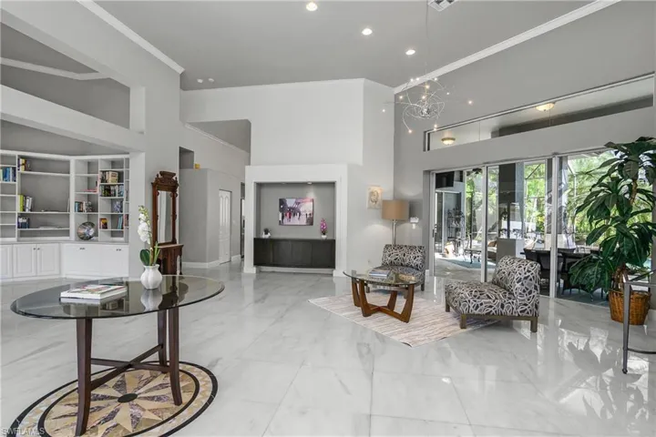 Formal Living area featuring crown molding, a high ceiling, built in features, and hanging lights