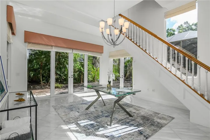 dining area featuring a high ceiling, french doors, and hanging lights