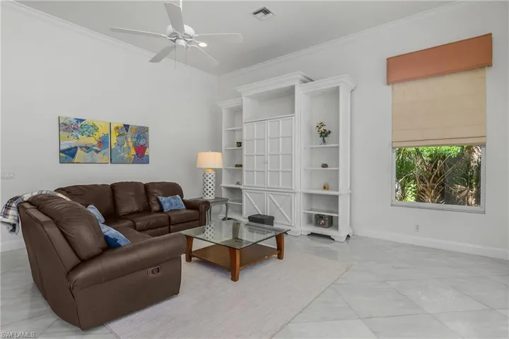 Living room with ceiling fan and crown molding