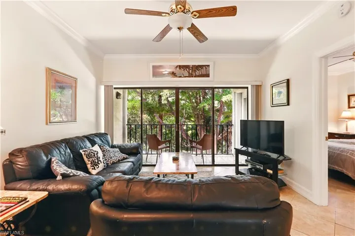 Living room featuring ceiling fan, light tile patterned flooring, ornamental molding, healthy amount of natural light, and baseboards