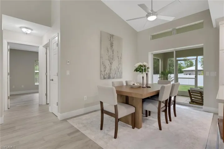 Dining area featuring wood-finish flooring, vaulted ceiling, and a modern ceiling fan