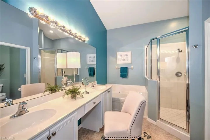 Primary Bathroom Featuring Dual Vanity w/Make-Up Area, Vaulted Ceiling, and Separate Tub & Shower