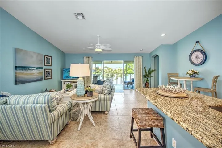 Living room featuring light tile patterned floors and ceiling fan