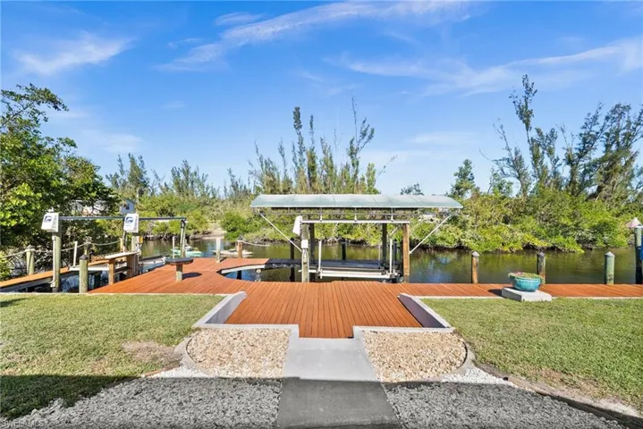 Dock area with a water view and a lawn