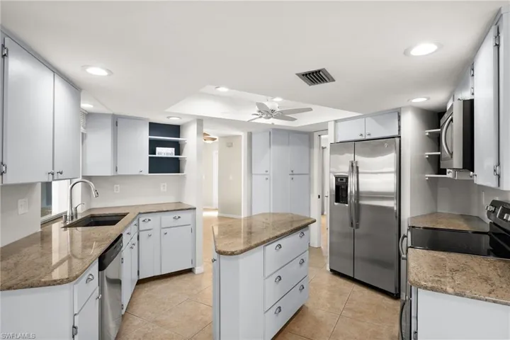 Kitchen with a center island, white cabinetry, sink, and appliances with stainless steel finishes