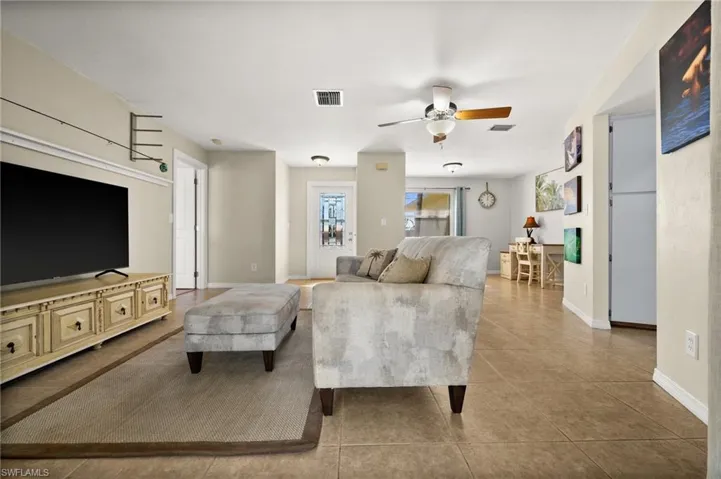 Living room featuring light tile patterned floors and ceiling fan