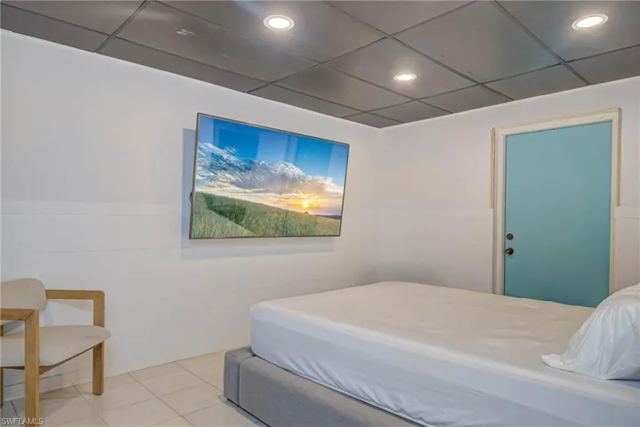Lower level - Bedroom featuring a paneled ceiling, recessed lighting, and light tile patterned floors