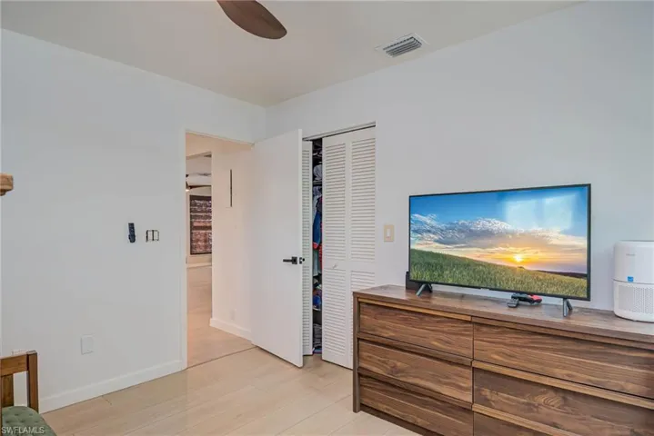Bedroom featuring NEW luxury vinyl plank, a closet, and ceiling fan- opens to hallway and living area