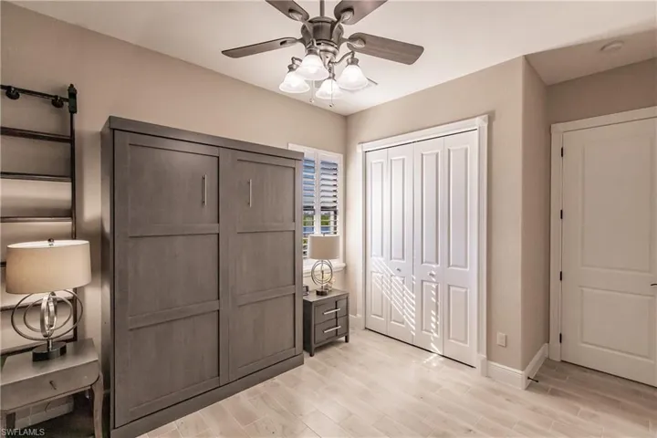 Bedroom 3 featuring ceiling fan, light wood-flooring, and murphy bed
