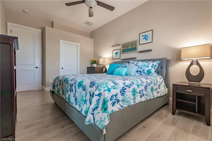 Ensuite Bedroom featuring ceiling fan and light wood-type flooring.