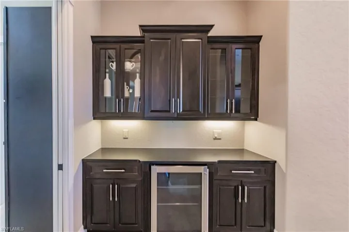 Butlers Pantry featuring dark brown cabinets and wine cooler