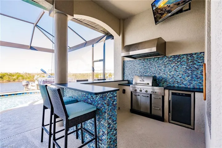 View of patio / terrace featuring area for grilling, a lanai, exterior kitchen, and exterior bar