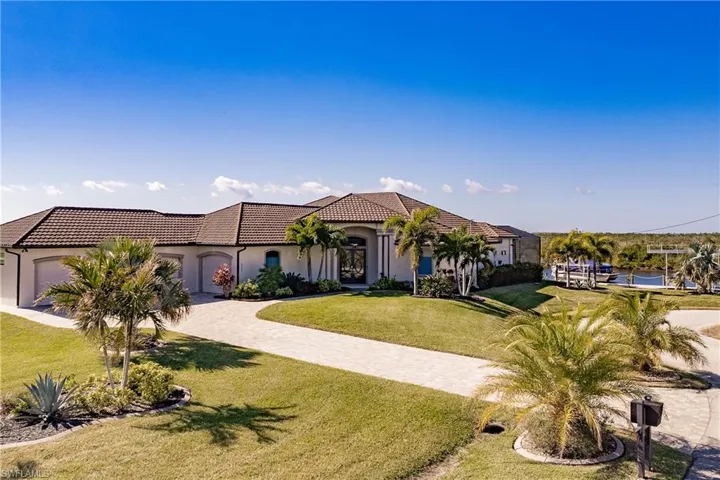 Front of home with green front lawn and 4  car garage