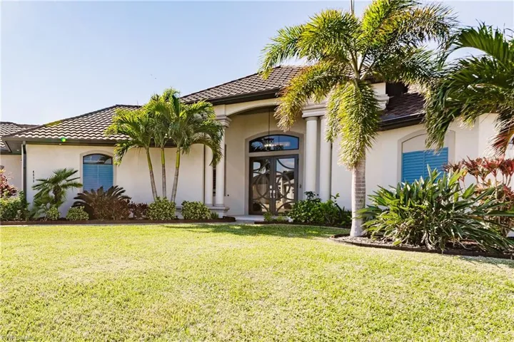 View of front of property featuring a front lawn and entry door