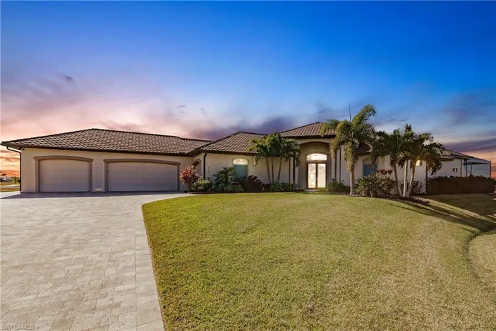 Mediterranean / spanish-style house with a lawn and a garage