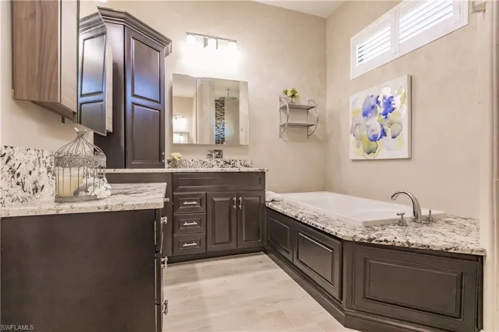 Bathroom featuring hardwood / wood-style floors, vanity, and a bath