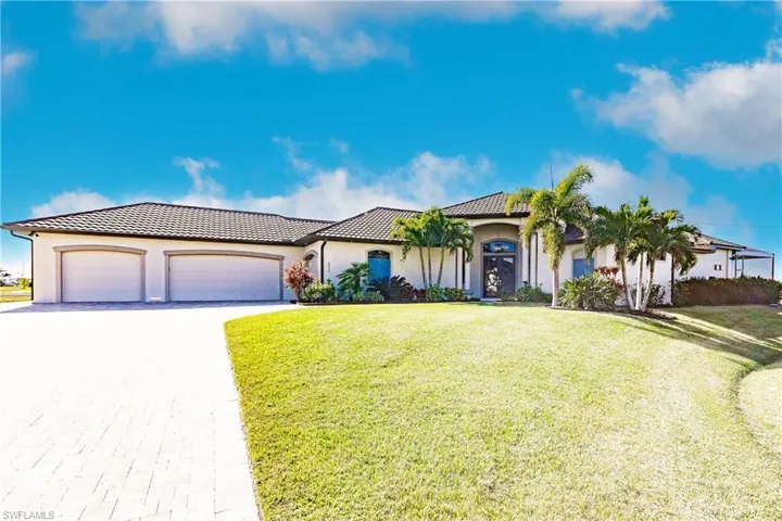 Front of home with green front lawn and 4  car garage
