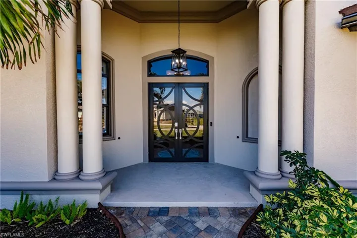 Doorway to property featuring decorative french doors and a porch