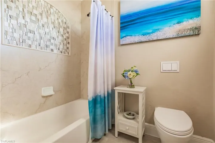 Bathroom featuring toilet and shower / tub combo
