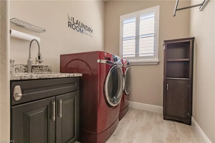 Laundry Room featuring separate washer and dryer, cabinets, and sink