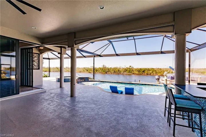 View of pool featuring a water view, ceiling fan, and a lanai