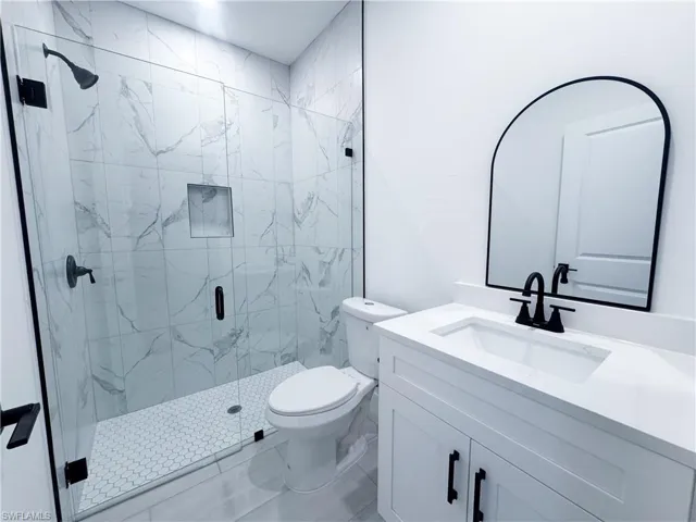 Full bathroom with a marble finish shower, vanity, and marble finish floors
