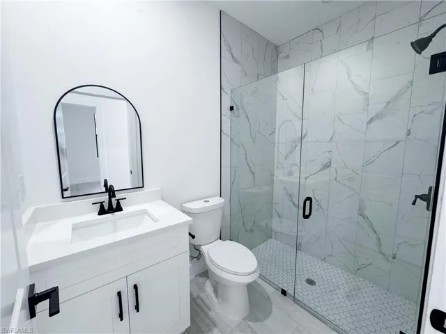 Full bathroom with vanity and a marble finish shower