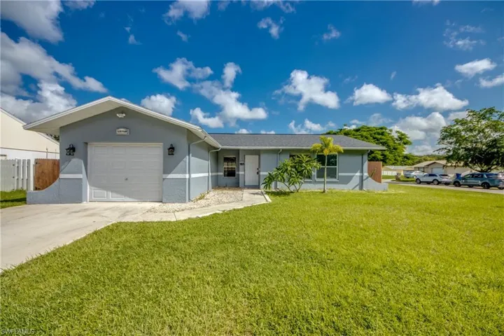 Single story home with a garage and a front yard