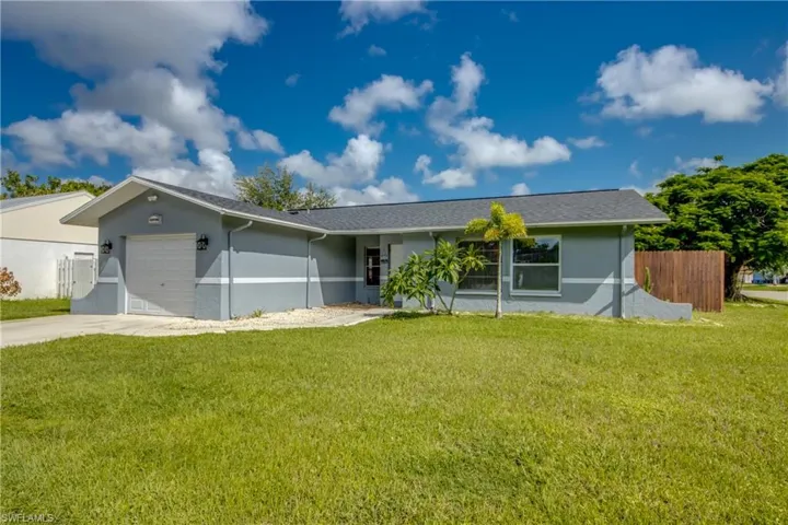 Ranch-style home with a garage and a front lawn